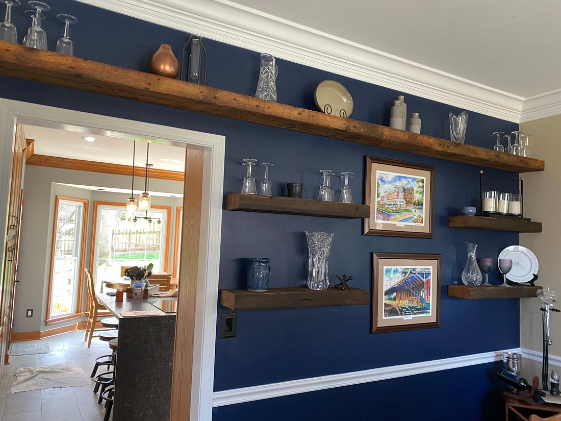 Reclaimed floating wood shelves on blue wall with white trim