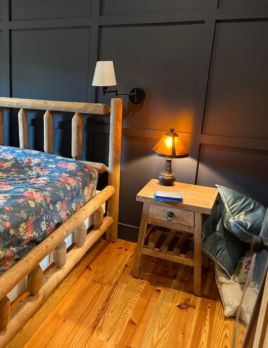 yellow pine wood flooring in bedroom with wood frame bed and wooden night stand