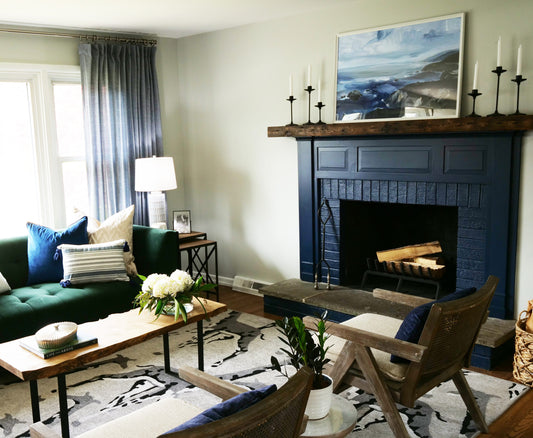 reclaimed barn wood fireplace mantel. Darker in color showing nail holes and grain pattern across the front. Displayed over a fireplace with long candles as decor.