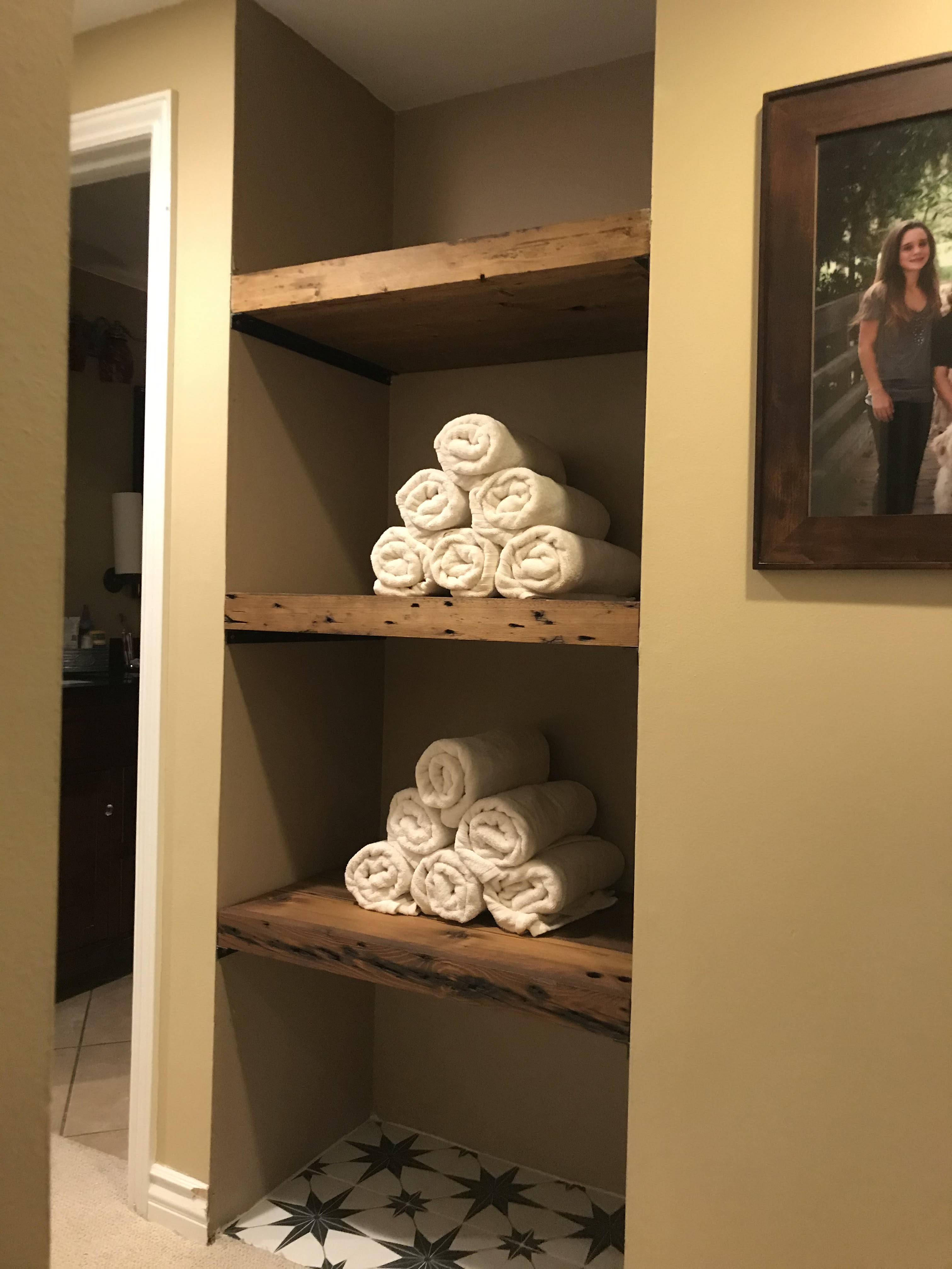 reclaimed wood shelving in common area with towel rolls on top