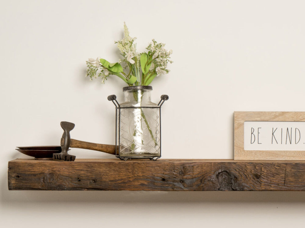 Reclaimed wood mantel with hammer and decor as well as a sign that says "Be Kind"