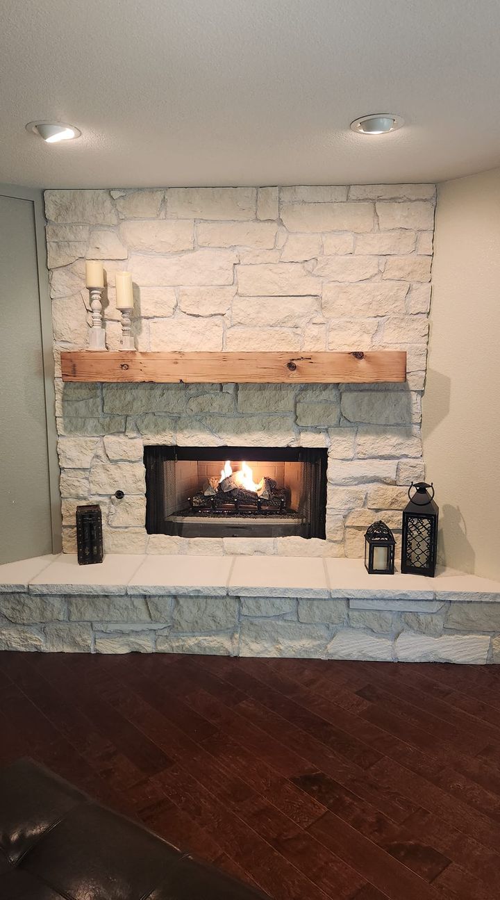 reclaimed wood mantel over fireplace with white brick