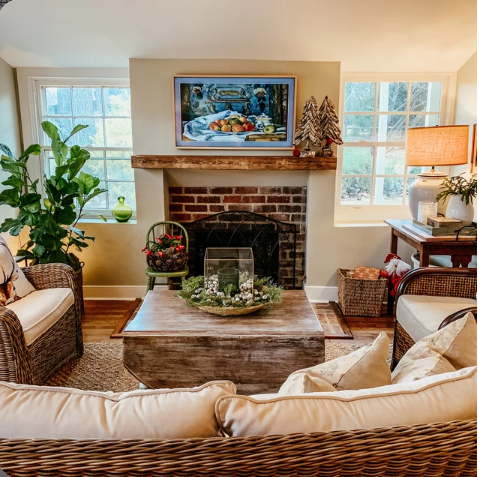 a reclaimed wood floating fireplace mantel in the oil finish. The mantel is mounted in a living room above a traditional brick fireplace.