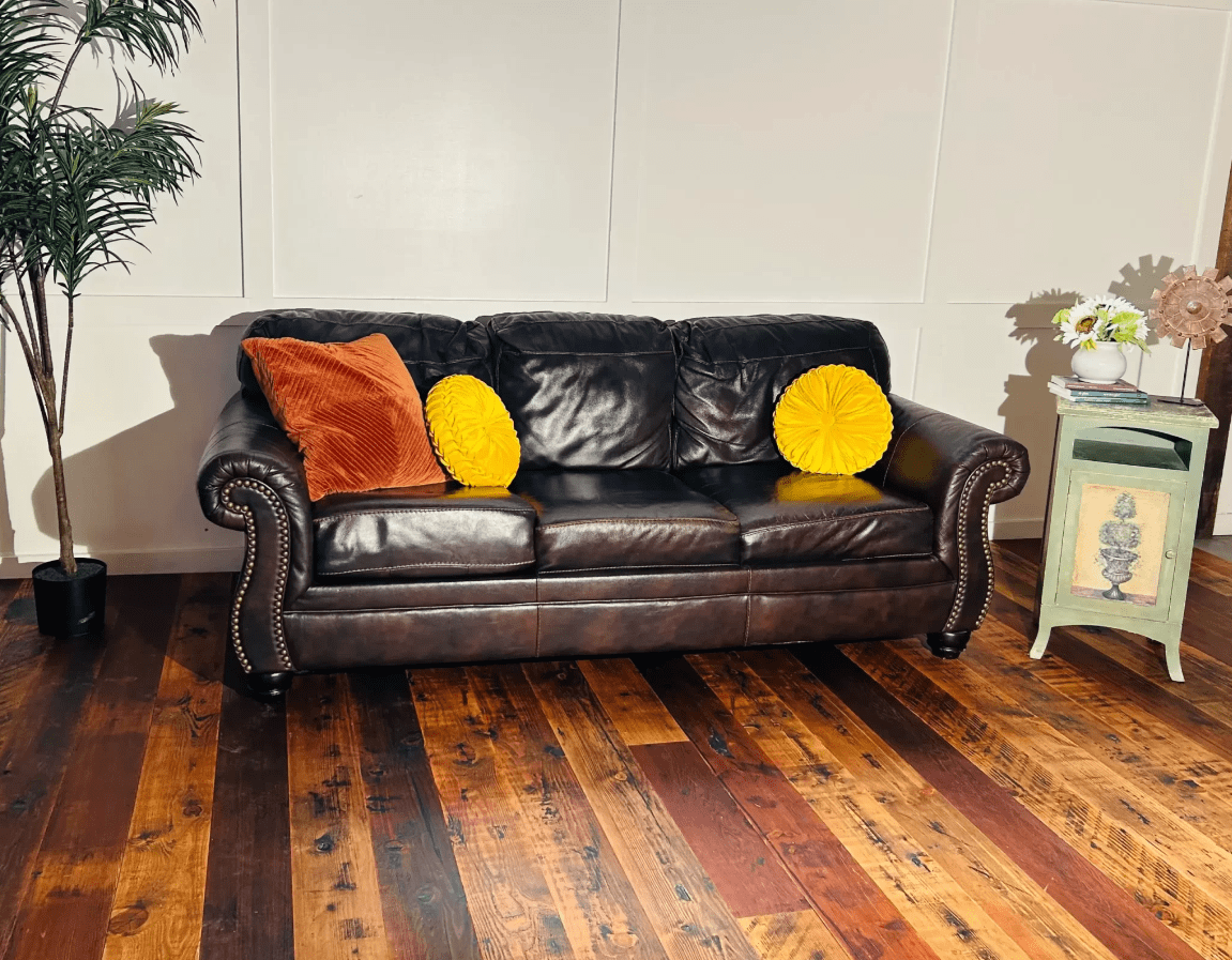 Douglas Fir wood flooring with leather couch, stand and plant in living room