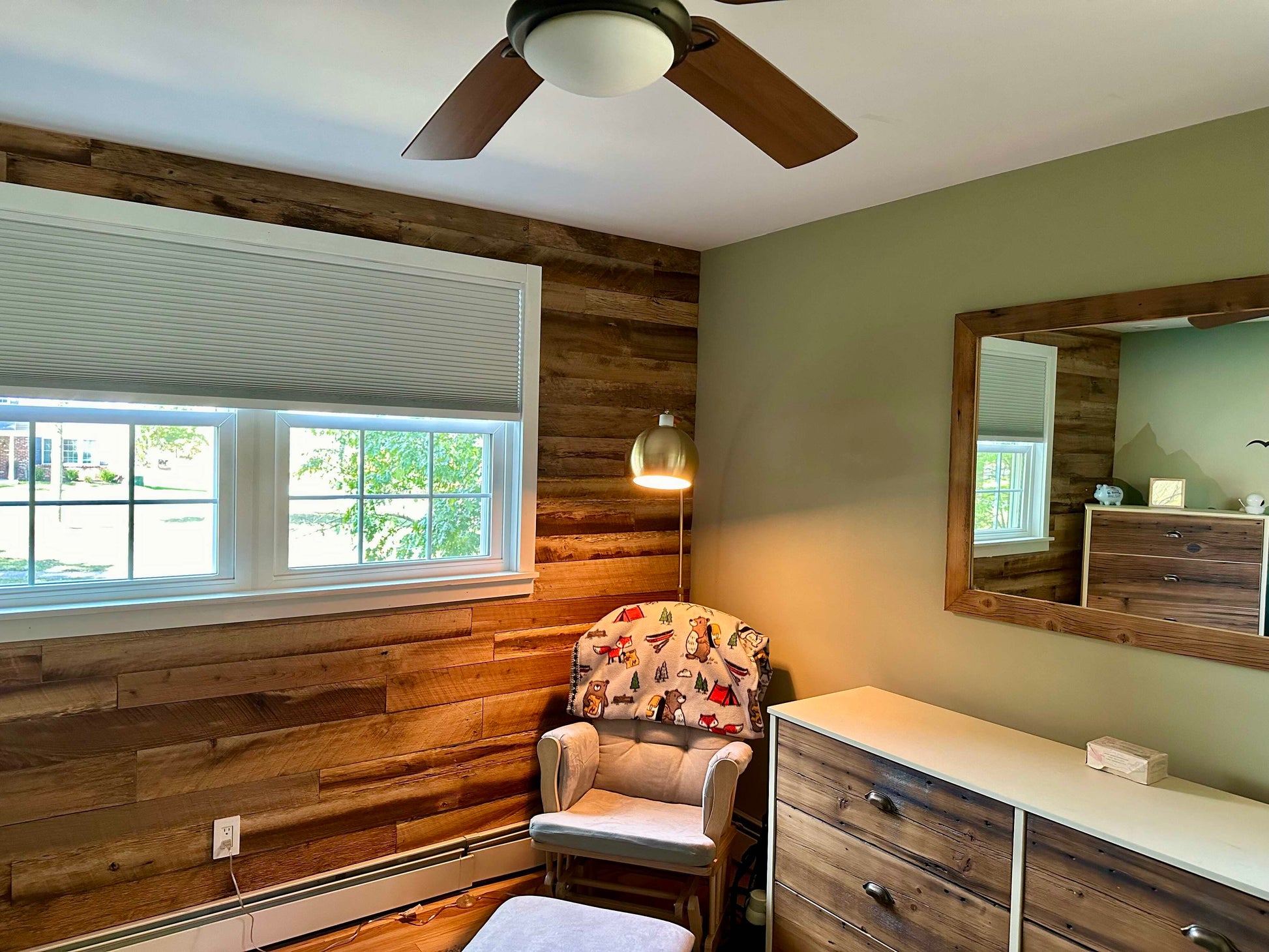 Mixed Species Brown Barnwood Paneling | Reclaimed Wood Wall Planks on accent wall with char and lamp in corner next to a dresser and mirror on a green wall.