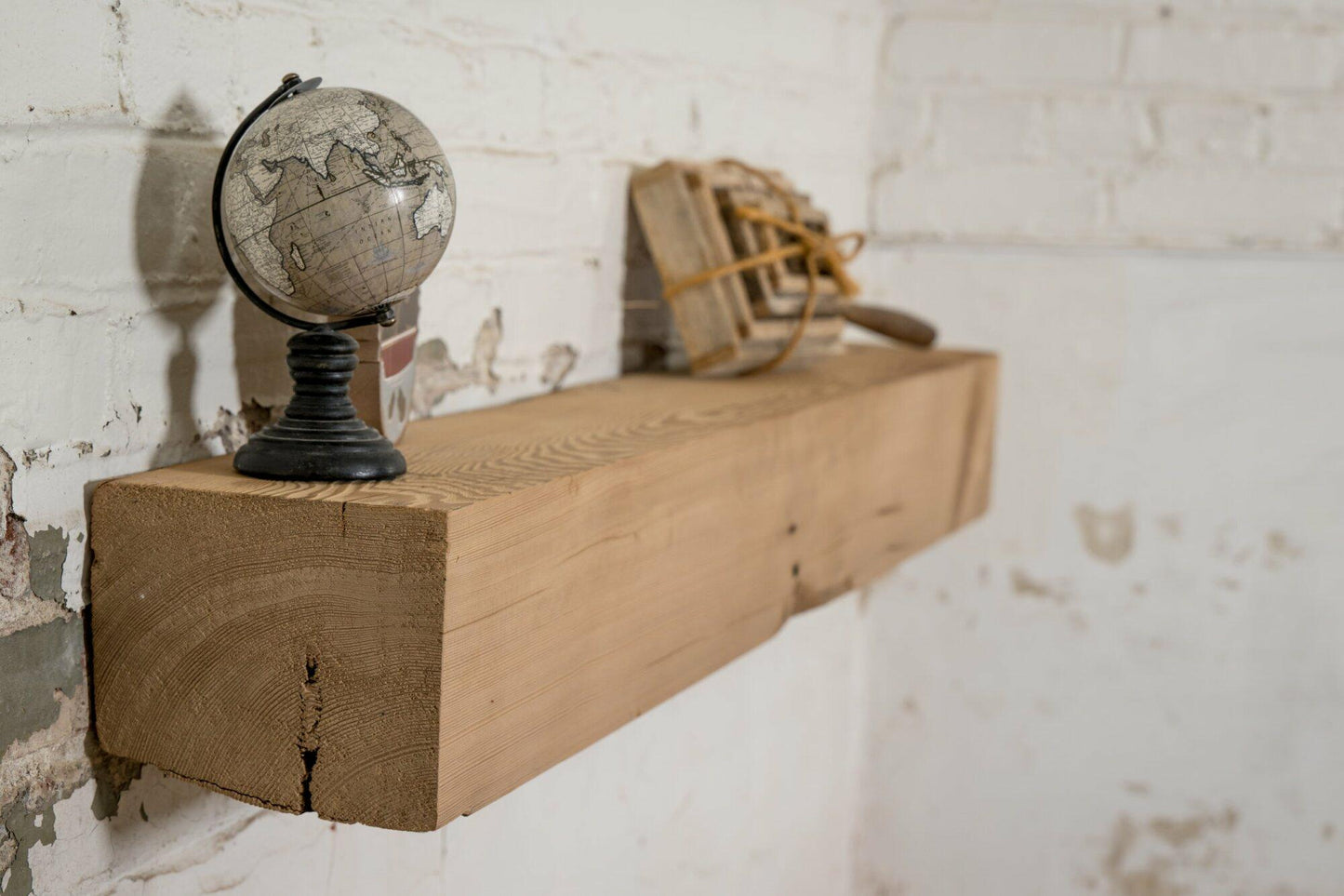 a close up of a reclaimed wood rustic fireplace mantel in the planed option. The angle shows a crisper top edge and grain pattern of the wood.