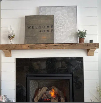 a reclaimed wood floating fireplace mantel in the natural option. The mantel has matching corbels shown underneath and has prominent nail holes in the face