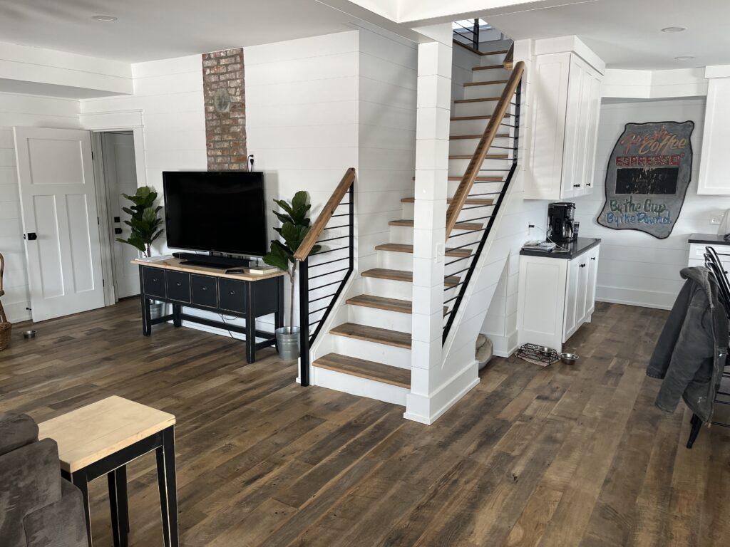 Heartland Barnwood Oak Red & White Mixed Skip-Planed Brown wood flooring in living area and kitchen of modern home with white walls