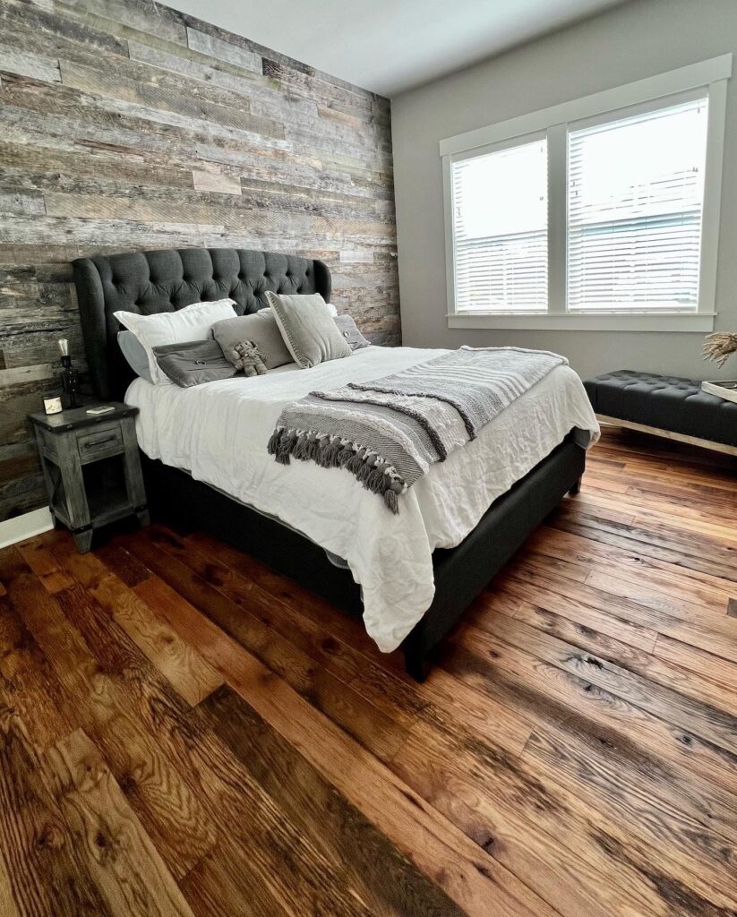 Racehorse Oak Red & White Mix Skip/Wire-Brushed flooring in bedroom with modern bed and wood wall paneling.