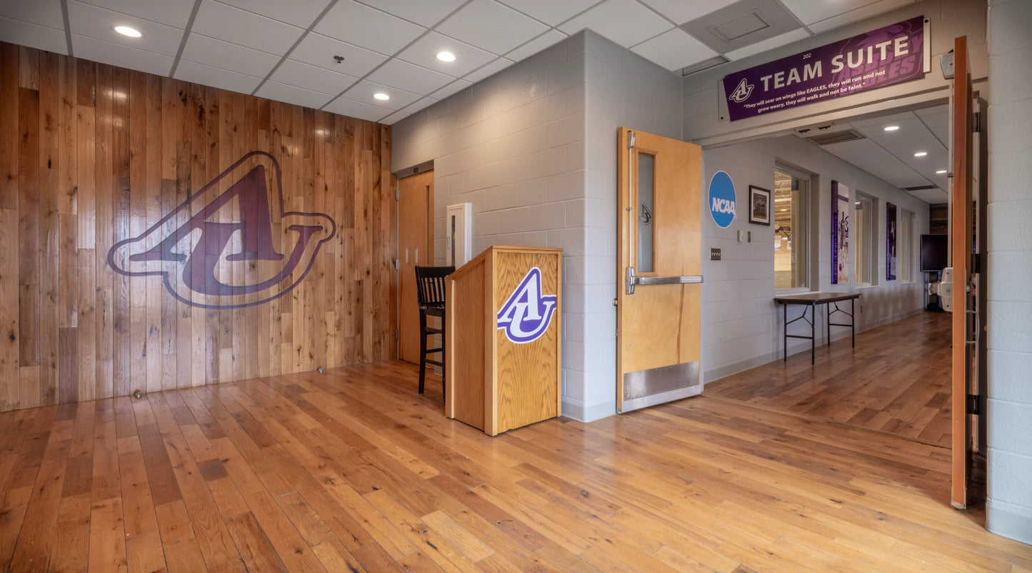 Racehorse Oak Red & White Mix Clean Face wood flooring and wall paneling used in university common area with logo on wall.