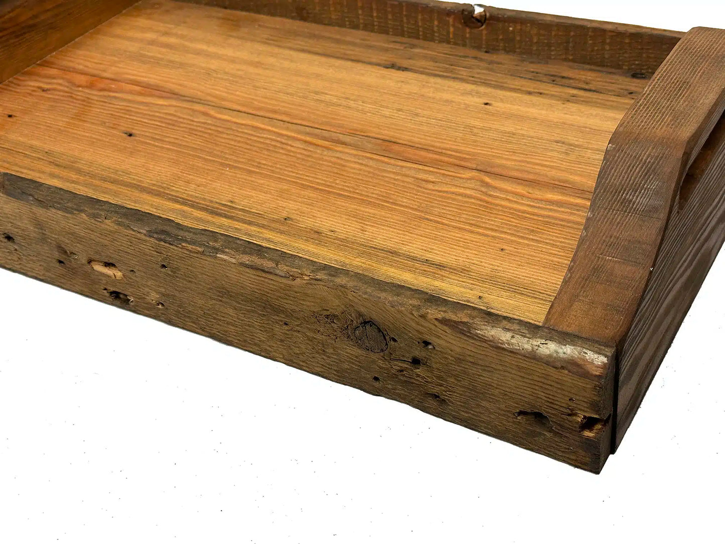 close up of wood characteristics displayed in the reclaimed wood used to create the serving tray. Shows smooth surface of tray itself and rounded handles.