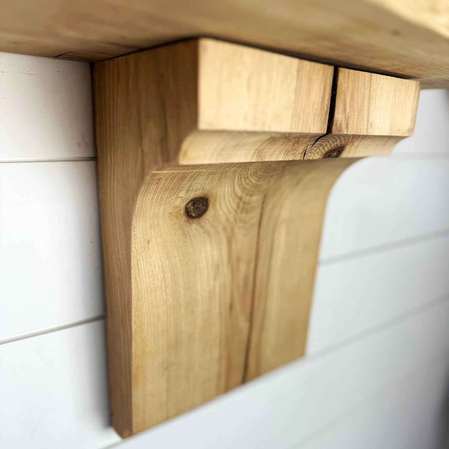 Reclaimed wooden corbel on white wall close up