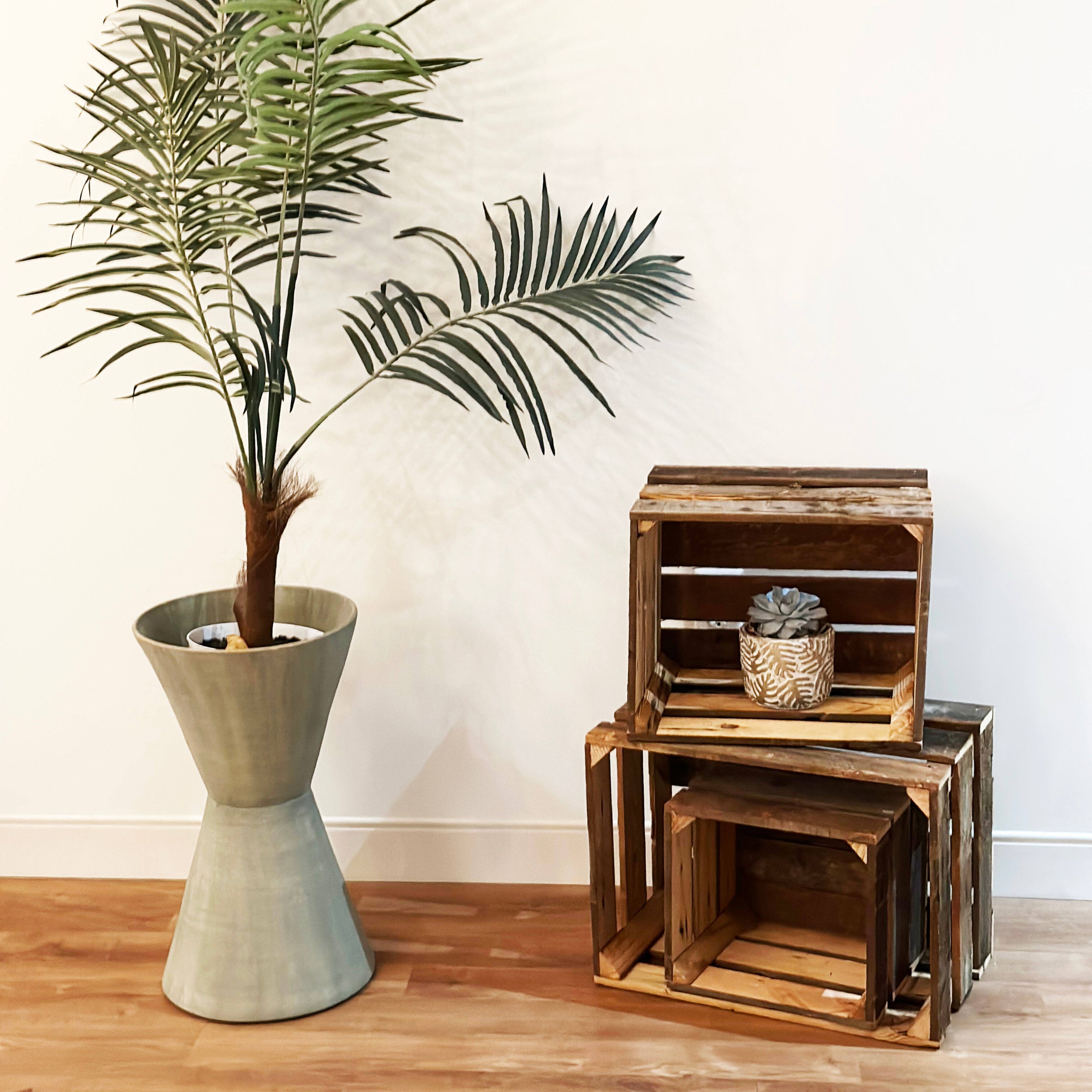 home decor image with wooden crates and plant in vase with wood flooring