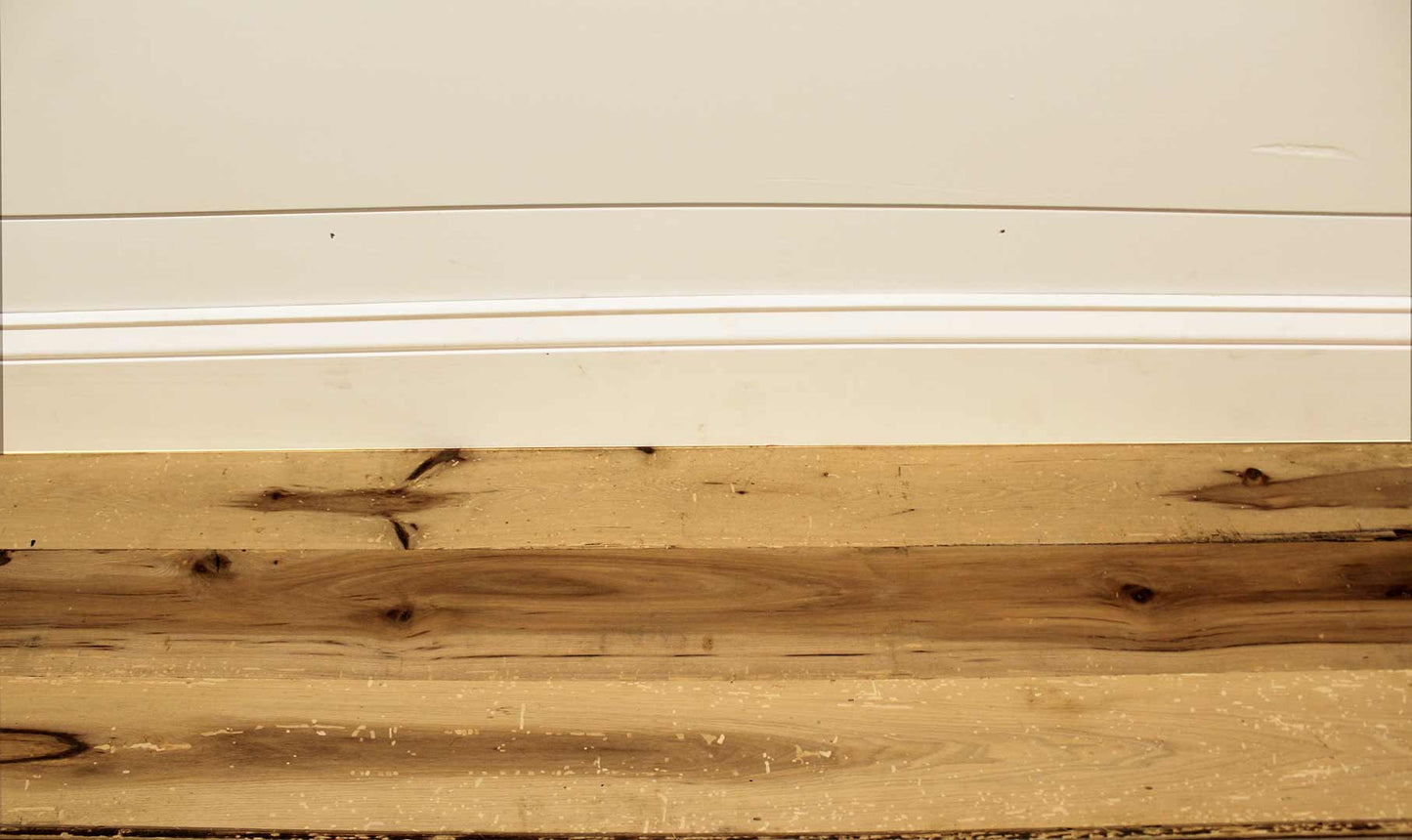 reclaimed hickory flooring installed with baseboard molding. Wood has variations in color and show knots and characteristics from previous bug activity.