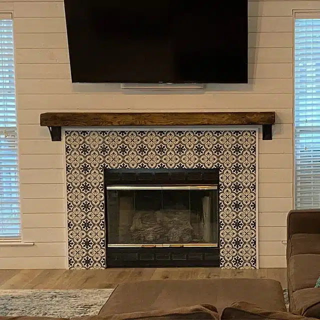 a reclaimed wood floating fireplace mantel in the oil finish. The mantel is mounted above a tile fireplace, on a shiplap wall with a television mounted above. Grain patterns are prominent and highlighted from the oil finish application.