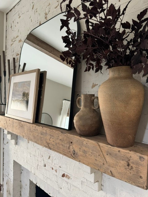 Reclaimed wood mantel with decor and mirror on top