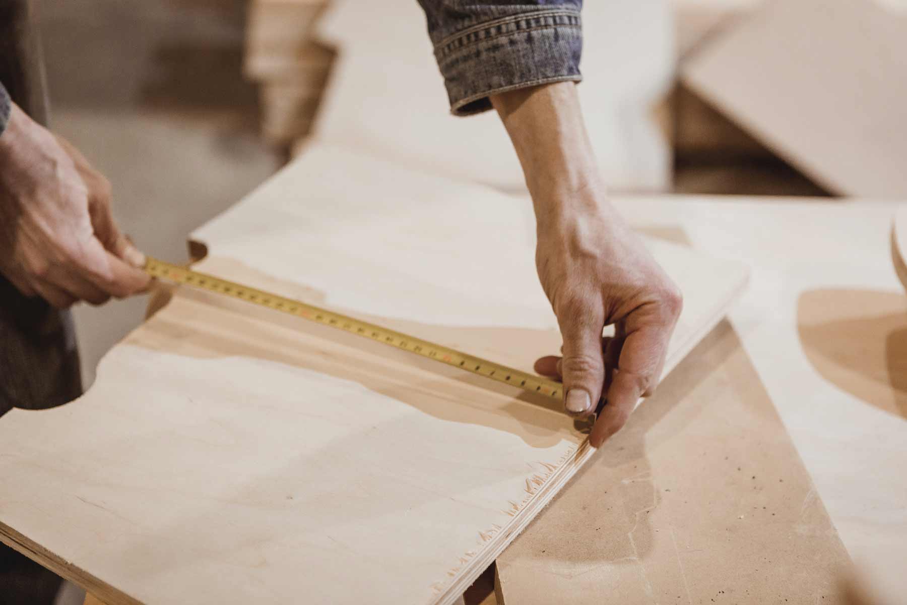 Person measuring wood with a tape measure
