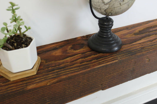 close up of a skip-planed reclaimed barnwood fireplace mantel in the oil finish. The oil finish brings out variations of color and grain pattern in the wood.