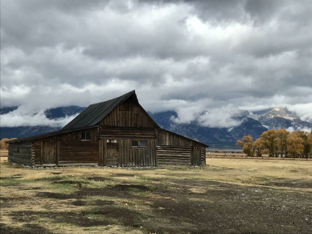 Old Barn in field with mountains in background
