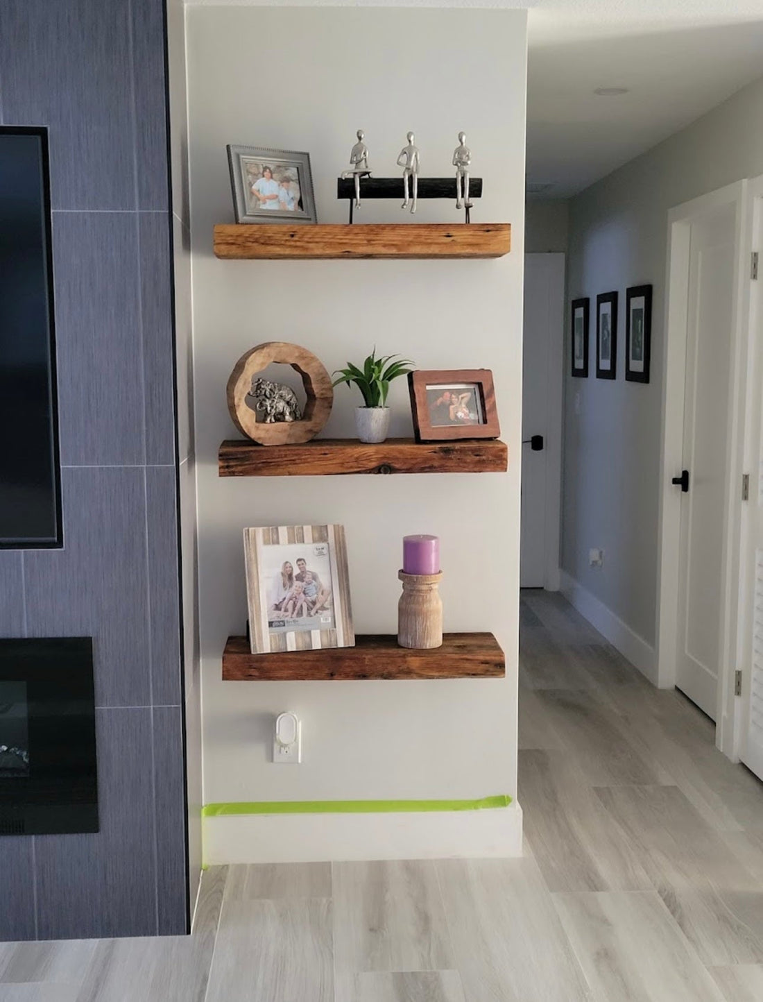 3 tier reclaimed wood shelving next to fireplace