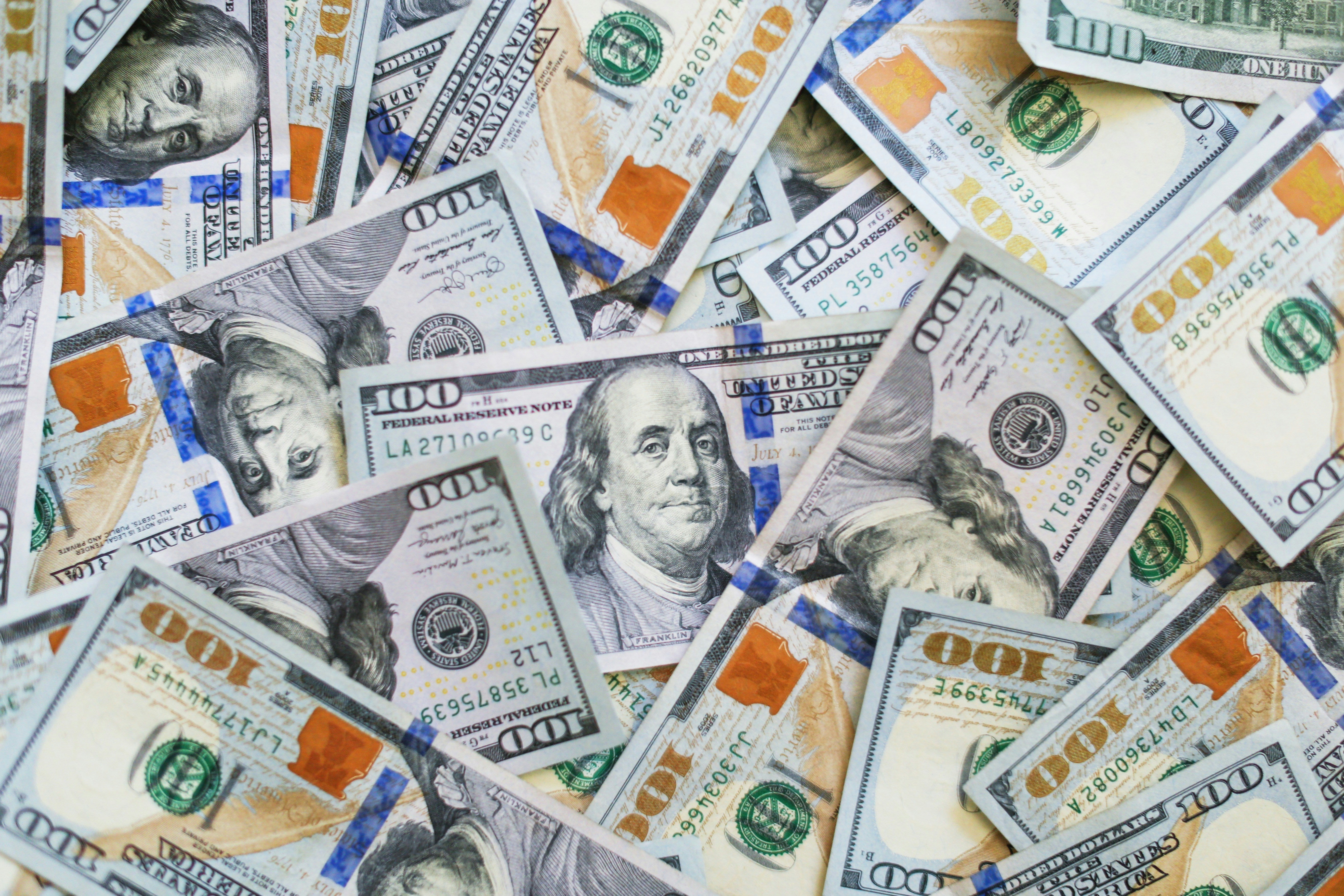 pile of one hundred dollar bills