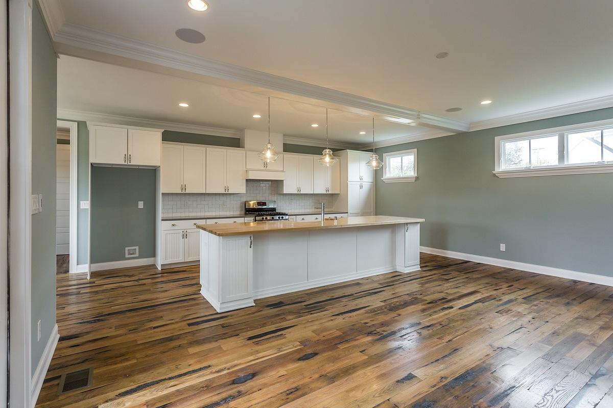 Racehorse Oak Red & White Mix Skip-Planed Black wood flooring in living area looking into kitchen