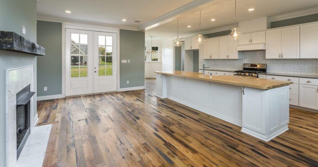 Racehorse Oak Red & White Mix Skip-Planed Black wood flooring in living area with fireplace and kitchen