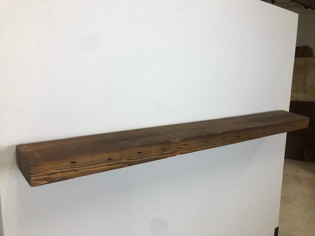 66" Skip-Planed Reclaimed Barn Wood Fireplace Mantel Shelf - 3x8 on white wall left angle view