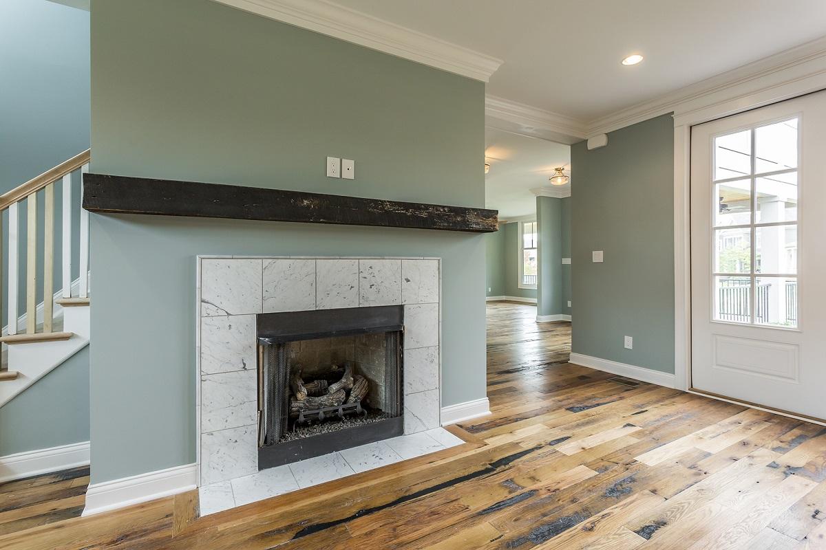 Racehorse Oak Red & White Mix Skip-Planed Black wood flooring in living area with fireplace