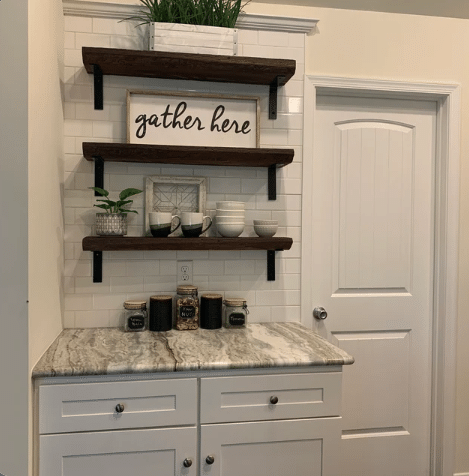 three reclaimed barnwood wall shelves shown in the early american finish. Shelves are in a small kitchen area shown on a subway tile backsplash.