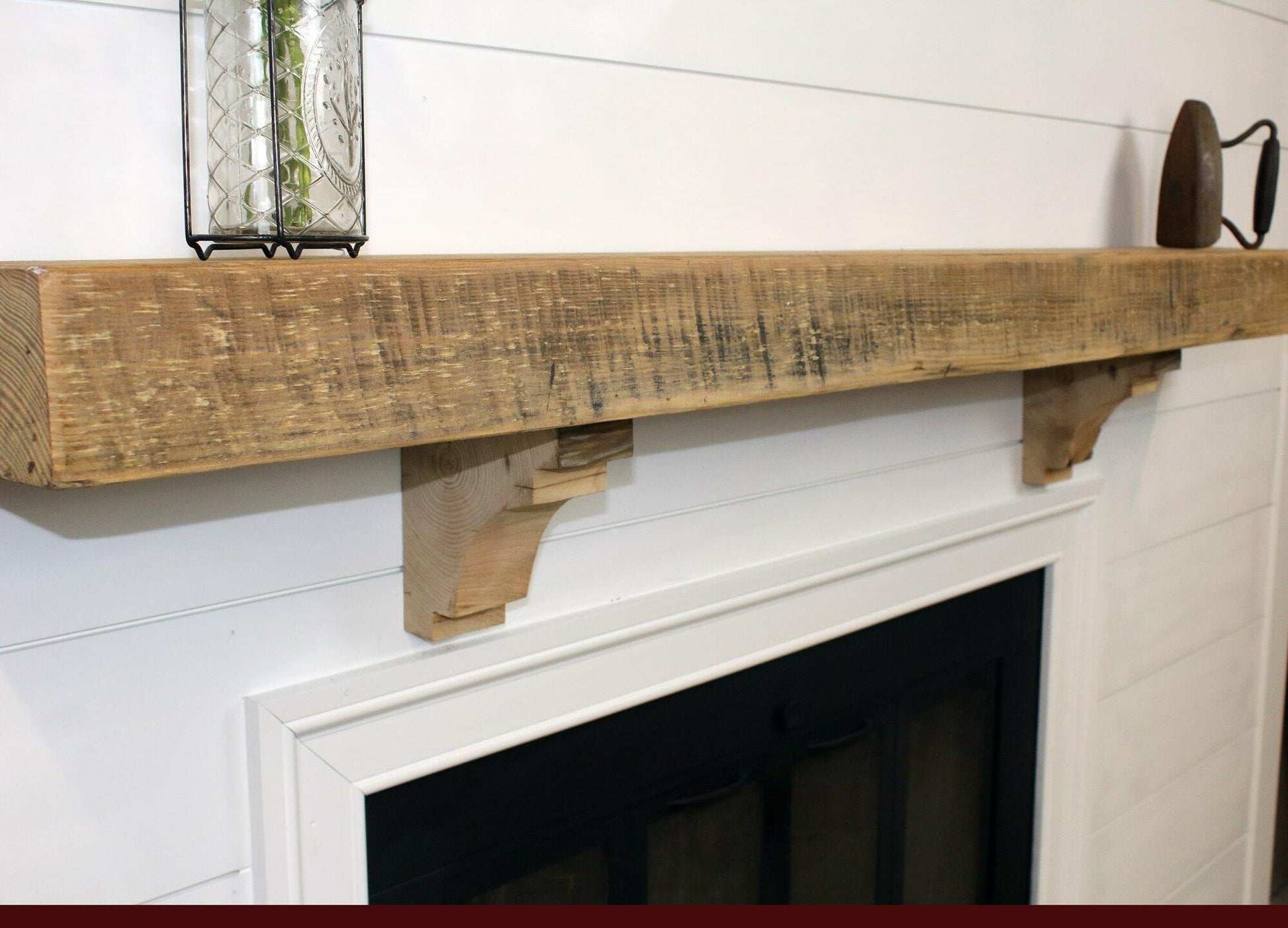 a close up of a reclaimed wood floating fireplace mantel in the natural option. The mantel has matching corbels shown underneath and has prominent saw markings in the face.