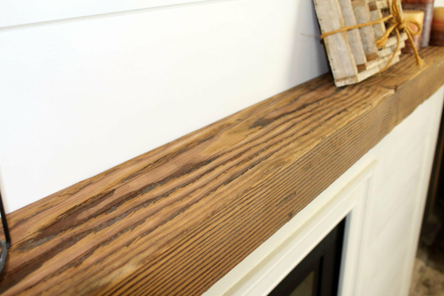 a close up of the top side of a skip-planed reclaimed barnwood fireplace mantel in the natural option. Close up images shows grain pattern and other variations in the wood.