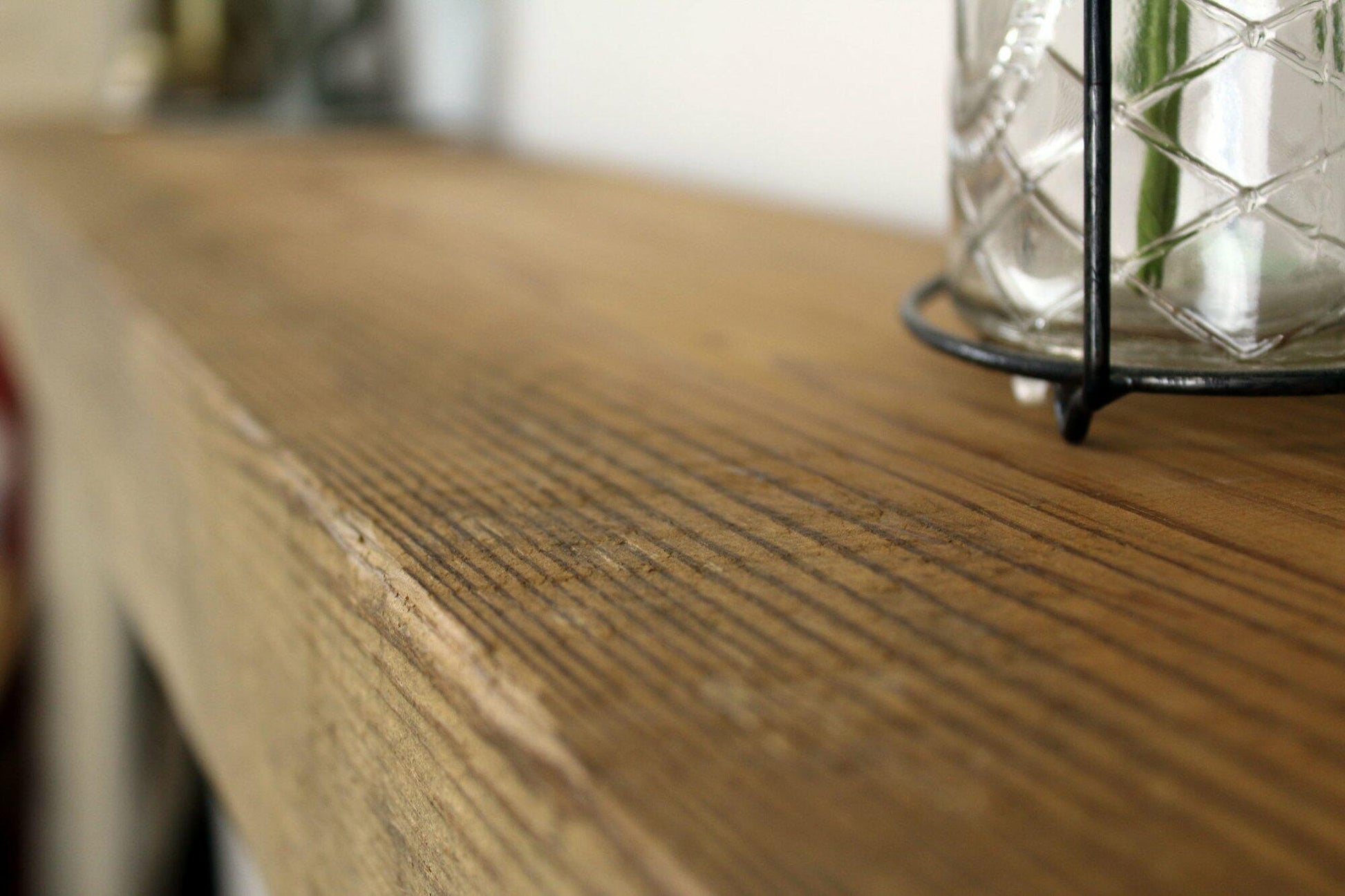 a close up of the top side of a skip-planed reclaimed barnwood fireplace mantel. Close up images shows grain pattern.