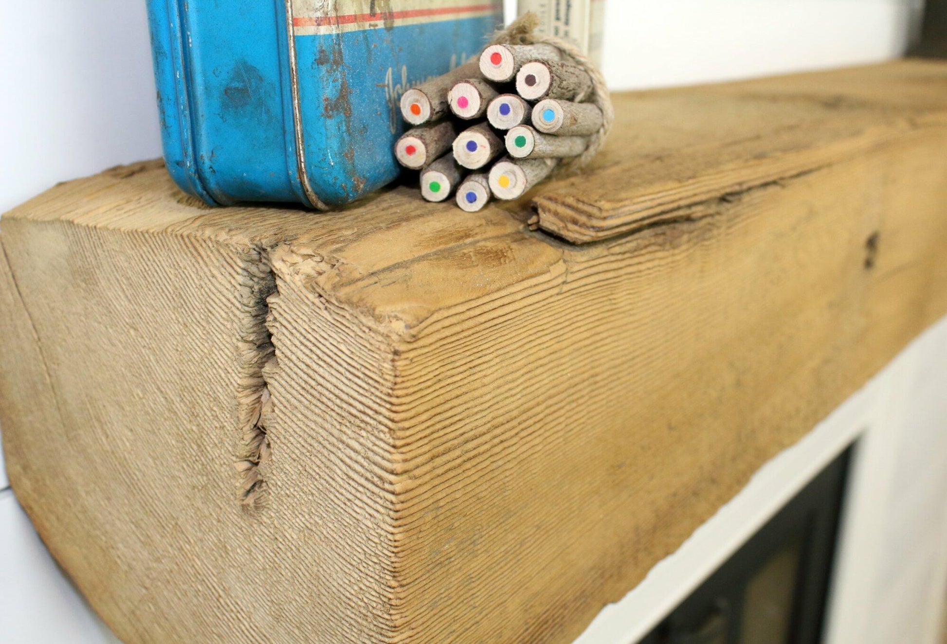 a close up of a reclaimed wood fireplace mantel in its natural color in the sanded option. Roughness of mantel, grain patterns, and texture are shown.