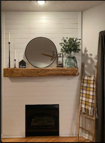 natural wood colored, hand hewn beam showing the woods grain patterns on a light shiplap fireplace. Mantel shows light axe marks and grain patterns.