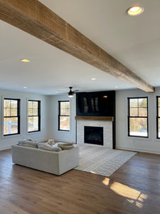 Reclaimed Wood Mantel in minimal living room with couch and wood beam in ceiling