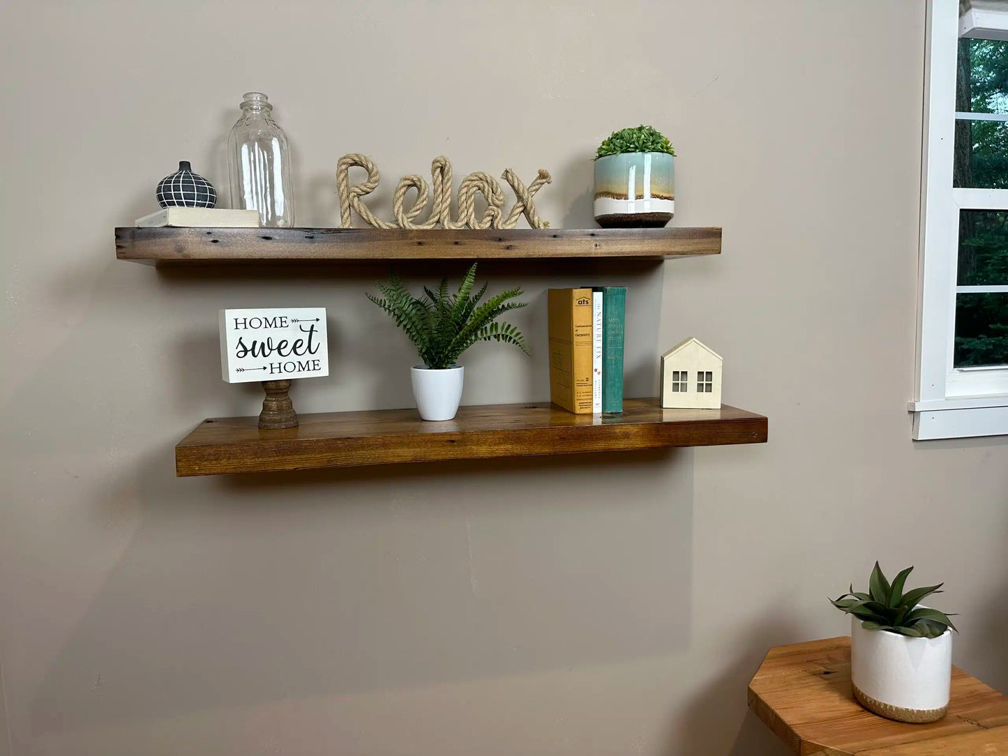 two reclaimed wood floating wall shelves in the contemporary collection and early american finish. Shelves have a shine on them from a lacquer application and show variance in wood color as well as nail holes in the wood.