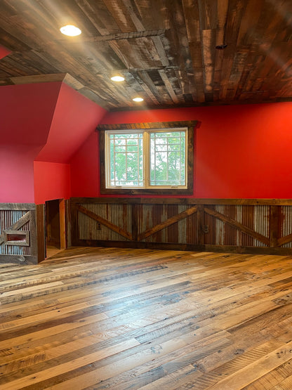 Heartland Barnwood Mixed Hardwoods Skip-Planed Brown flooring, wood panel ceiling and red walls with wood wall trim in barn style room 