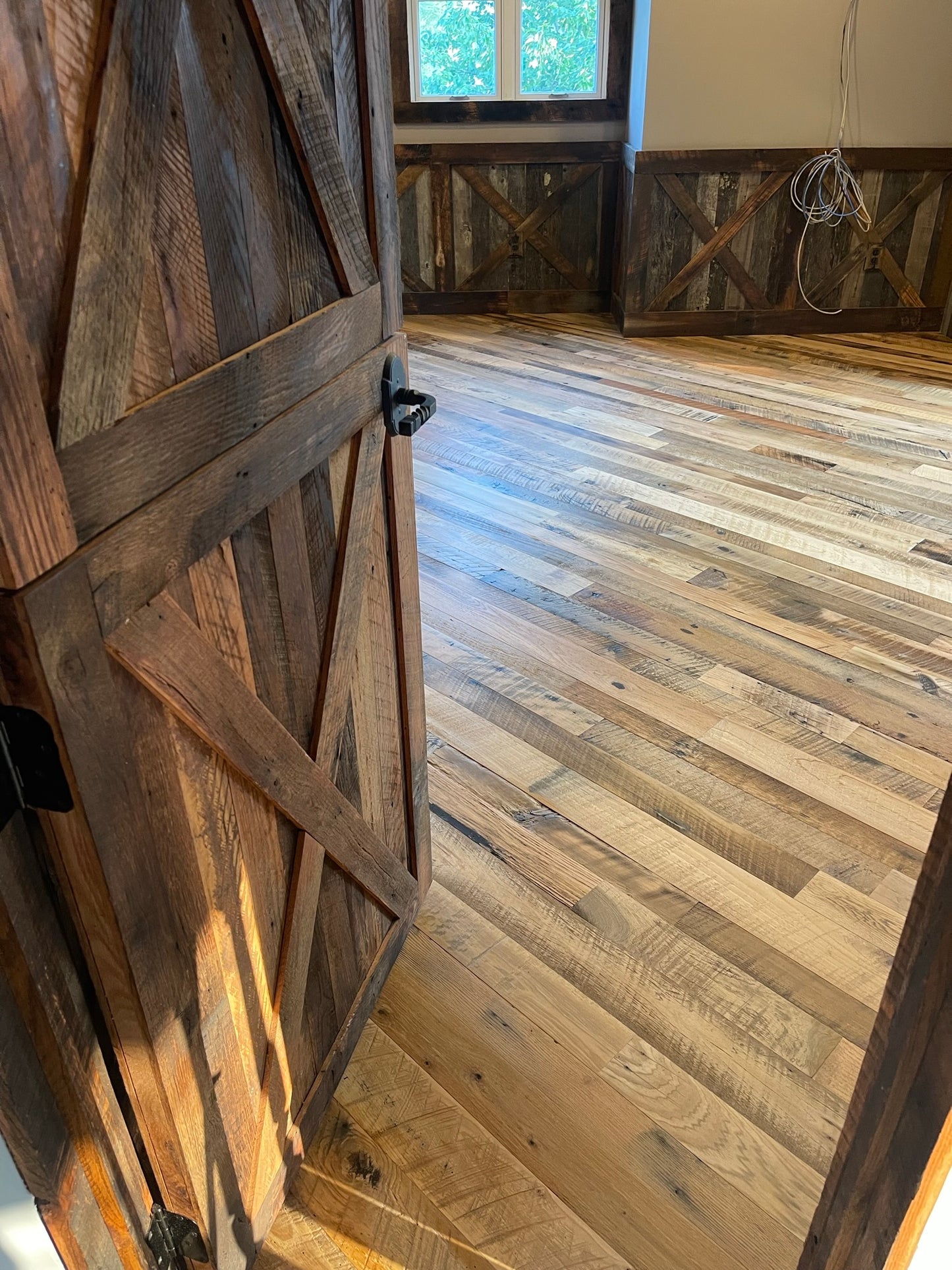 Heartland Barnwood Mixed Hardwoods Skip-Planed Brown flooring used in bed room  with wooden door