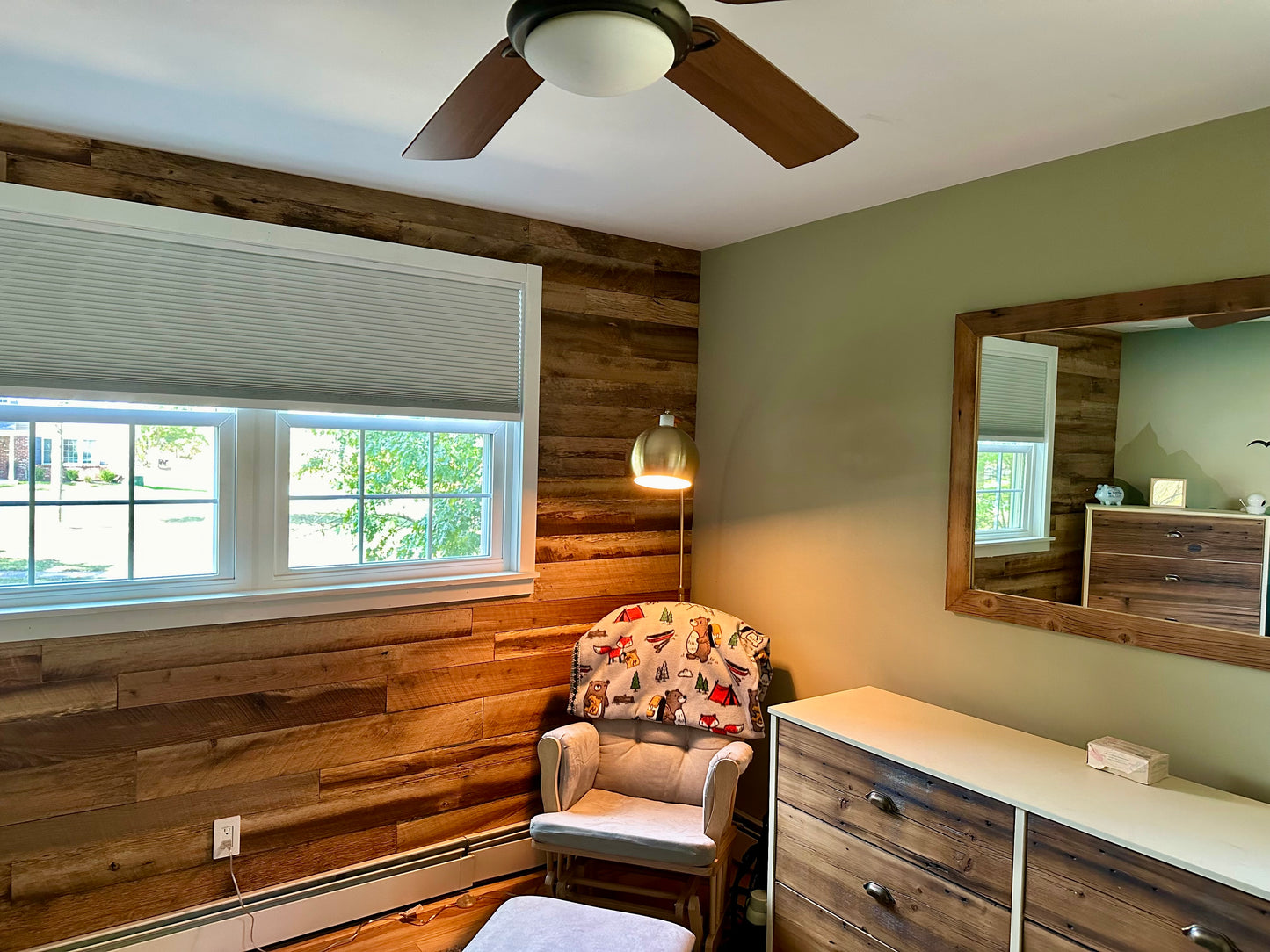 Mixed Species Brown Barnwood Paneling | Reclaimed Wood Wall Planks on accent wall with char and lamp in corner next to a dresser and mirror on a green wall. 