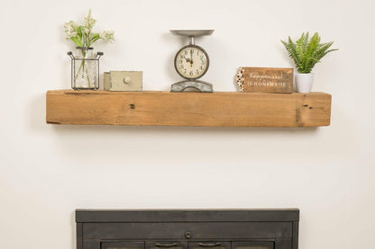 a reclaimed wood rustic fireplace mantel. The mantel is the natural color of the wood and texture, knots, and nail holes are present in the wood.