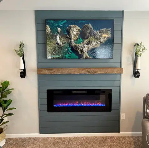 a reclaimed wood floating fireplace mantel in the natural option. Mantel provides contrast to darker colored shiplap fireplace it is mounted on.