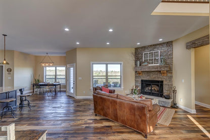  Heartland Barnwood Oak Red & White Mixed Skip-Planed Brown wood flooring in living room with stone fireplace