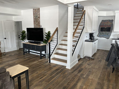 Heartland Barnwood Oak Red & White Mixed Skip-Planed Brown wood flooring   in living area and kitchen of modern home with white walls