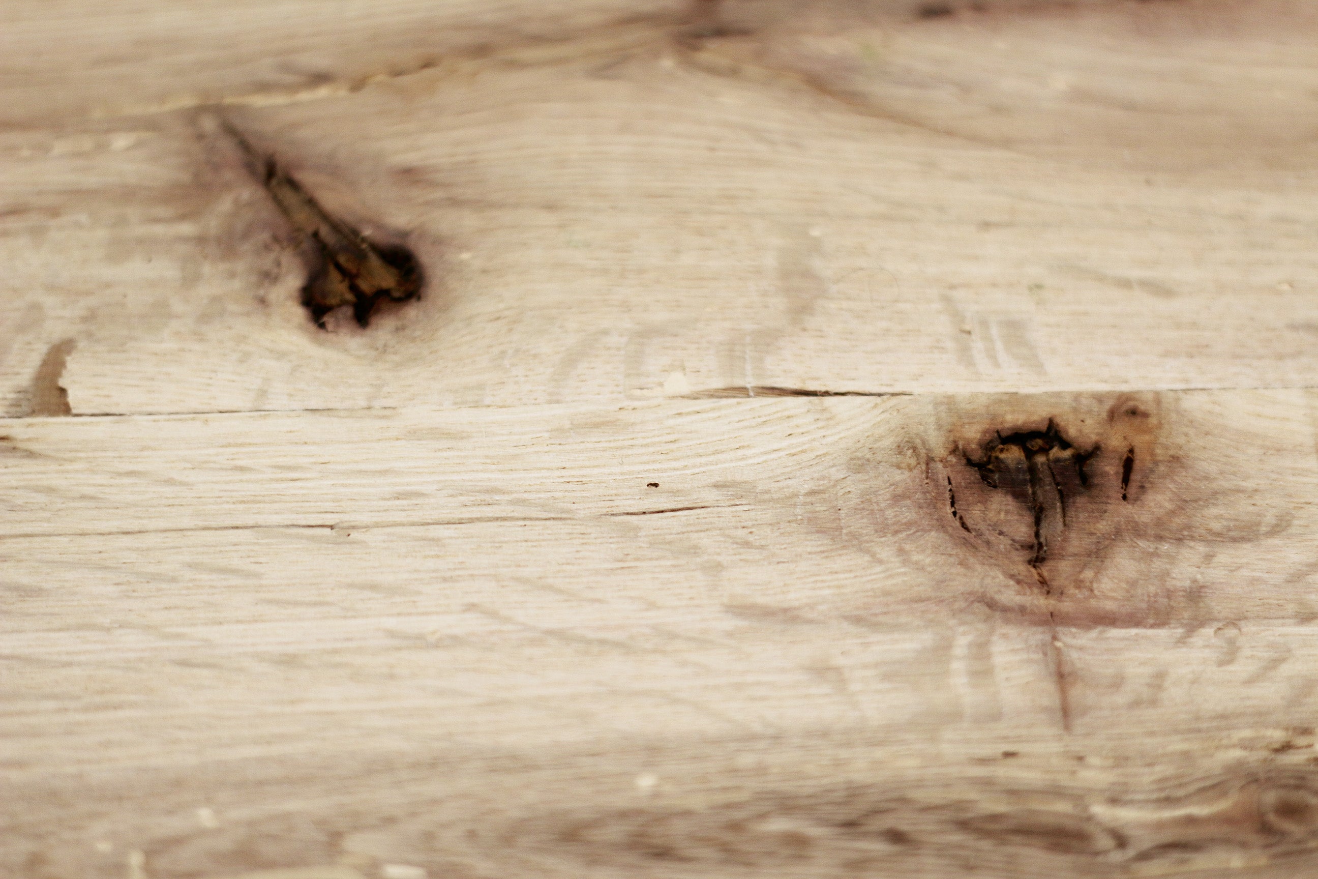 close up of red oak reclaimed flooring. Variations in wood color and grain pattern and knots shown.