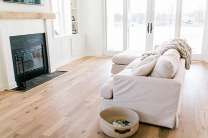 Racehorse Oak Red & White Mix Clean Face wood flooring in living room area with white couch and fireplace with mantel