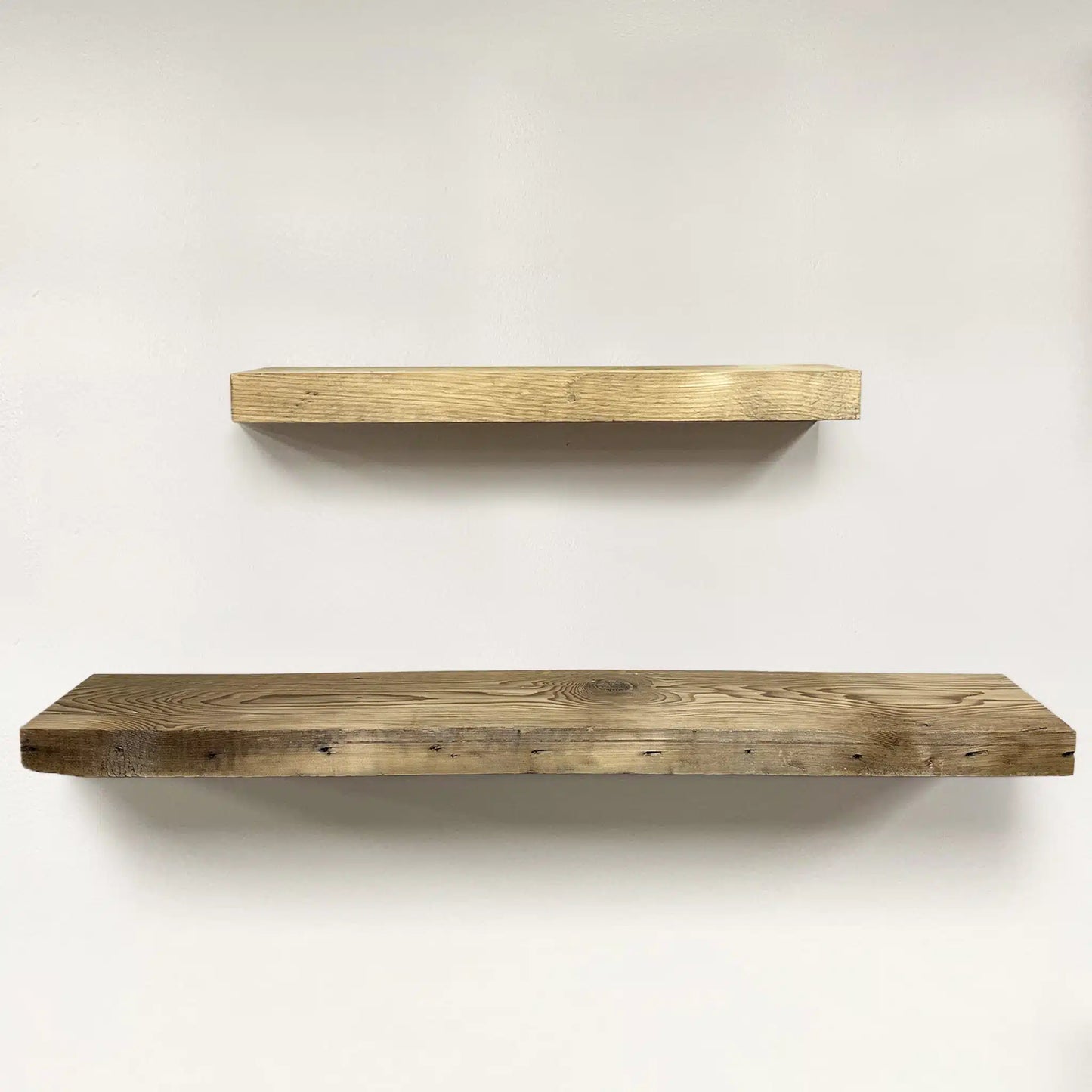 two reclaimed wood floating shelves in the unfinished option. Grain patterns, knots, and nail holes are shown in the wood.