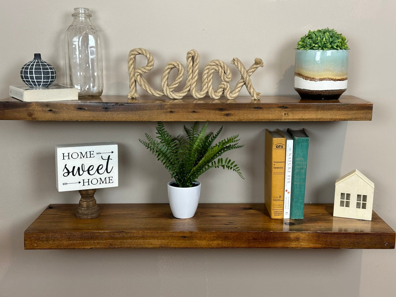 two reclaimed wood floating wall shelves in the contemporary collection and early american finish. Shelves have a shine on them from a lacquer application and show variance in wood color as well as nail holes in the wood.