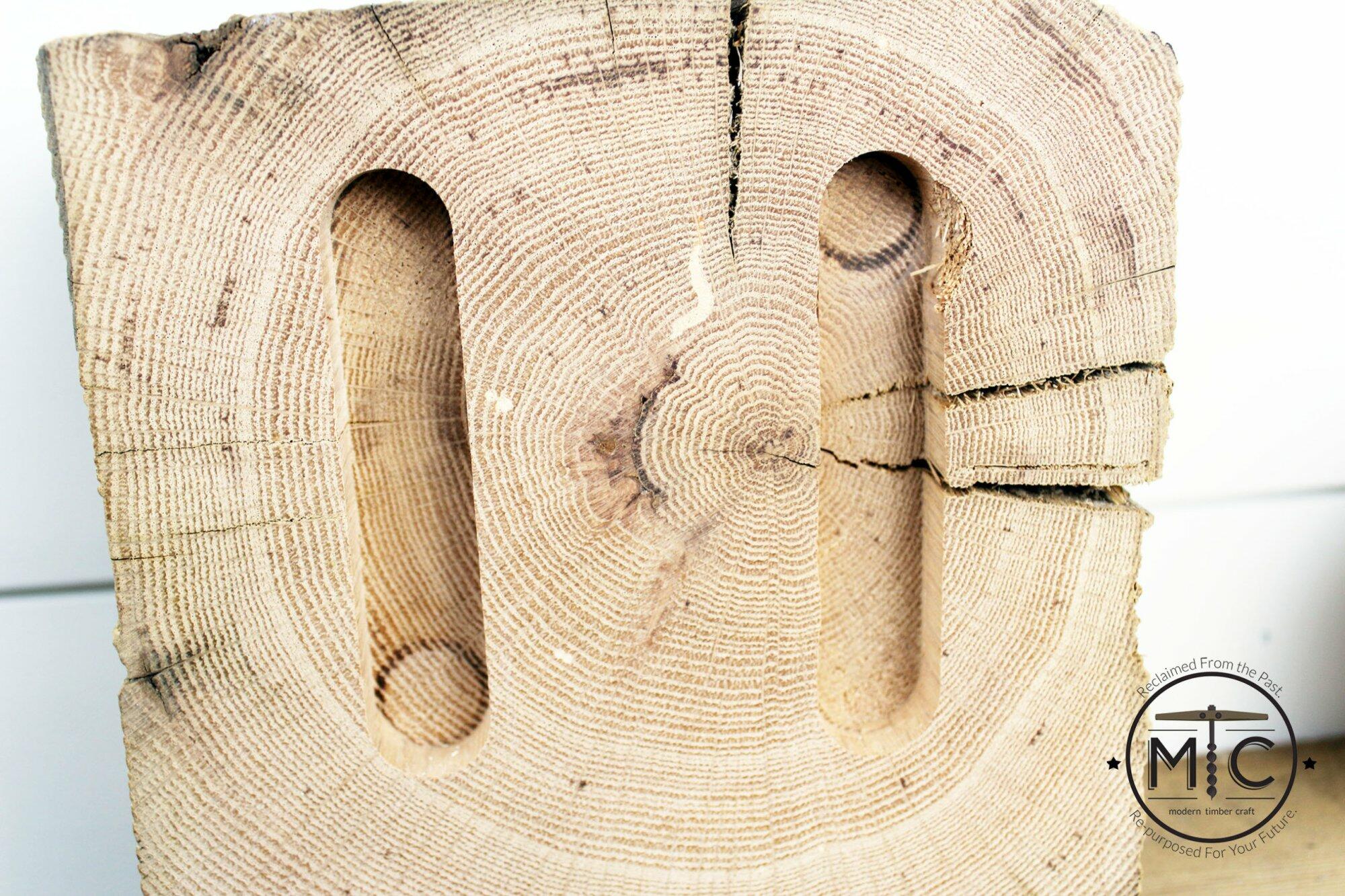 a close up showing the back of one of the wood blocks. The back has two routed channels for keyhole hardware to fit.