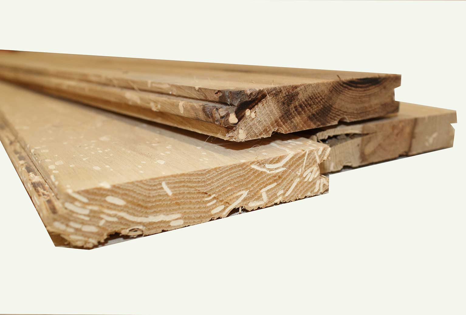 close up of ends of reclaimed hickory flooring. Shows square ends, tongue and grooves, and characteristics in the wood from previous bug activity.